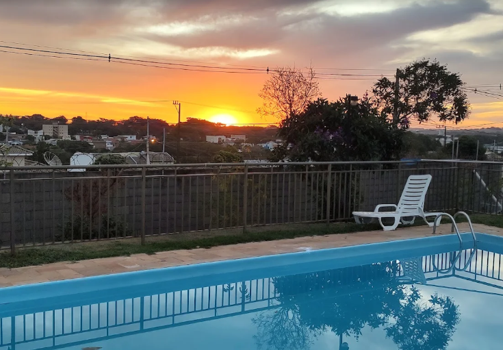 Piscina do condomínio com vista para o pôr do sol da cidade